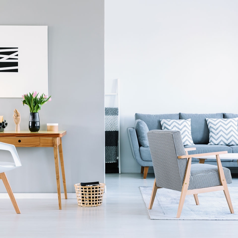A Stylish Modern Living Room Designed By The Best Real Estate Company In Bangladesh, Featuring A Blue Sofa, Wooden Furniture, And Minimalist Decor